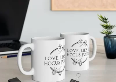 A picture of two mugs the Love, Lies, and Hocus Pocus logo printed on them.