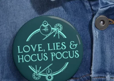 A picture of a button with the Love, Lies, and Hocus Pocus logo printed on it.