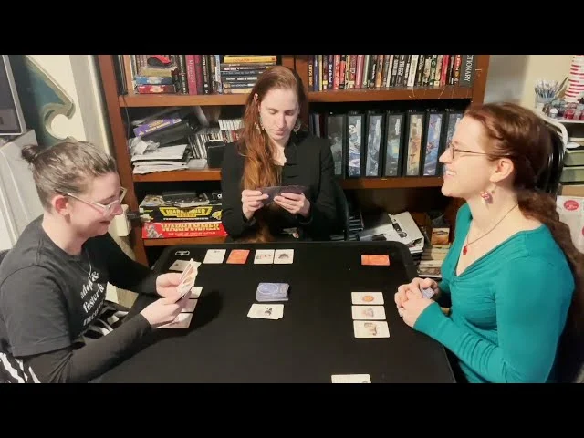 Clickable Video. A picture of Lydia and friends playing Cat Magic: The Game.